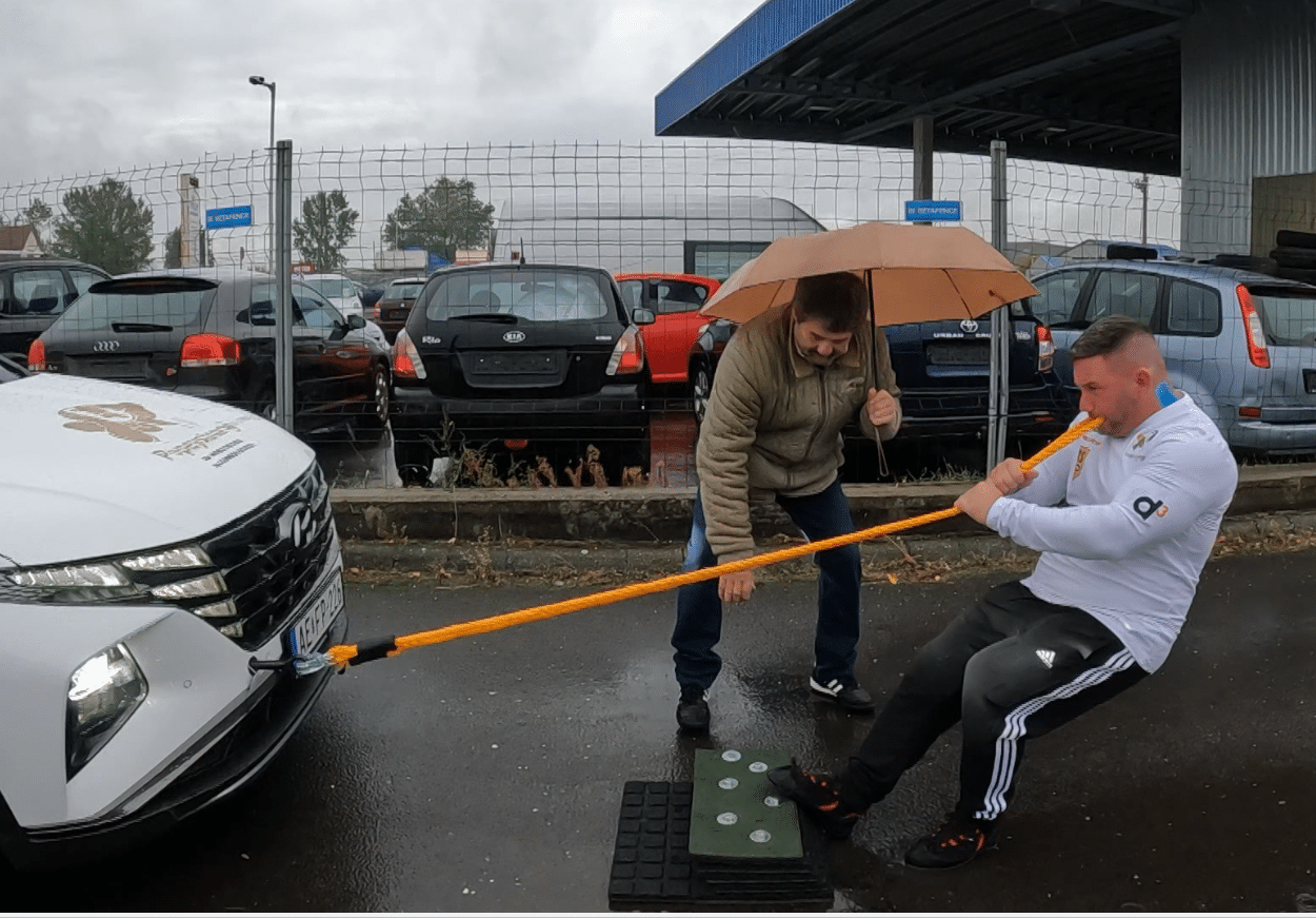 Új világrekord született ma Kecskeméten: Sinka "Popey" Zsolt 11 autót (24 tonna) húzott el foggal 31méter, 50cmre